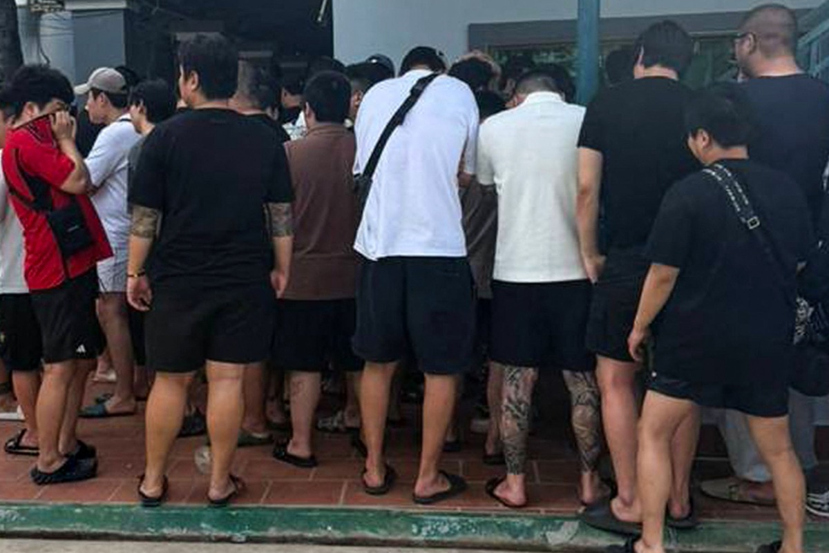 This undated handout from Agence Kampuchea Press (AKP) released on October 23, 2025 shows people, suspected of being involved in online scams, gathering during a raid on a scam centre in Phnom Penh. (Photo by Handout / Agence Kampuchea Press (AKP) / AFP)