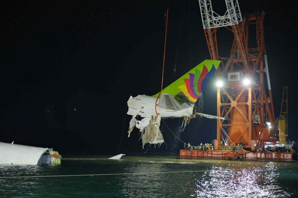 Crane hoisting the recovered the tail section an ACT Airlines Boeing 747-400 cargo aircraft released on October 25. Photo by Handout / Airport Authority Hong Kong / AFP)