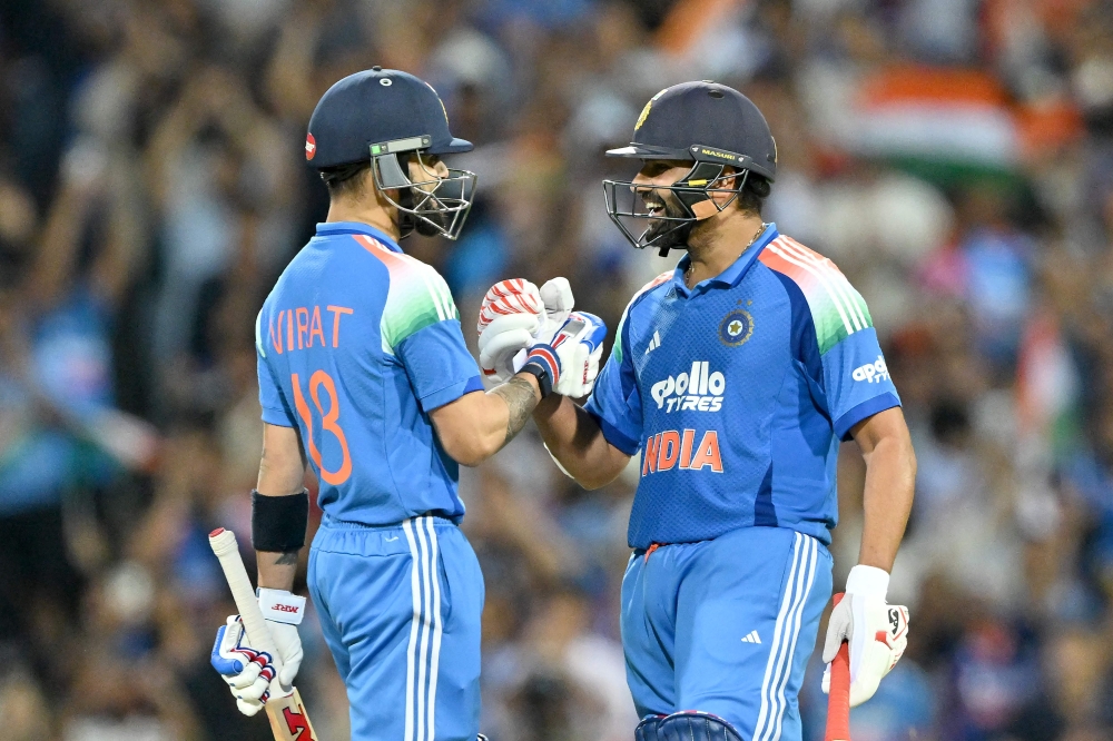 India's Rohit Sharma (R) and Virat Kohli celebrate their win at the Sydney Cricket Ground in Sydney on October 25, 2025. (Photo by Saeed Khan / AFP)