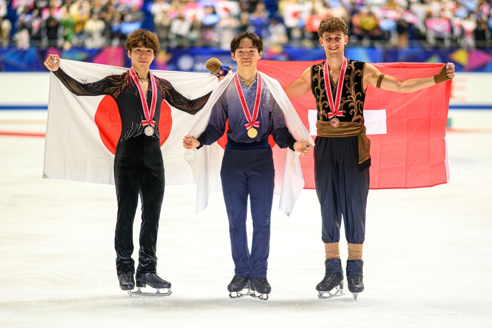 Silver medallist Japan's Shun Sato, gold medallist Japan's Yuma Kagiyama and bronze medallist Switzerland's Lukas Britschgi pose in the medal ceremony for the men's single during the NHK Trophy figure skating competition in Kadoma City. Photo by Philip Fong / AFP