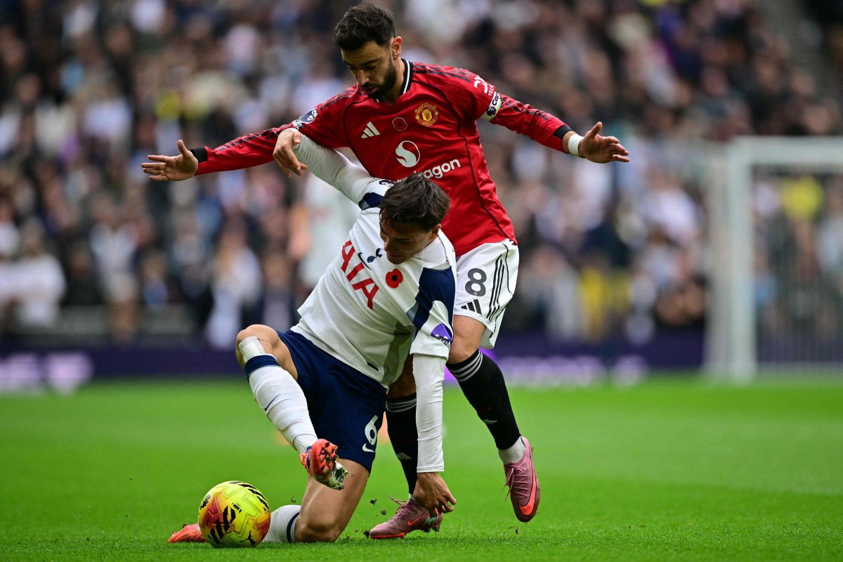 Tottenham Hotspur's Portugese midfielder #06 Joao Palhinha (L) vies with Manchester United's Portuguese midfielder #08 Bruno Fernandes (R) during the English Premier League football match between Tottenham Hotspur and Manchester United at the Tottenham Hotspur Stadium in London, on November 8, 2025. (Photo by Ben STANSALL / AFP)