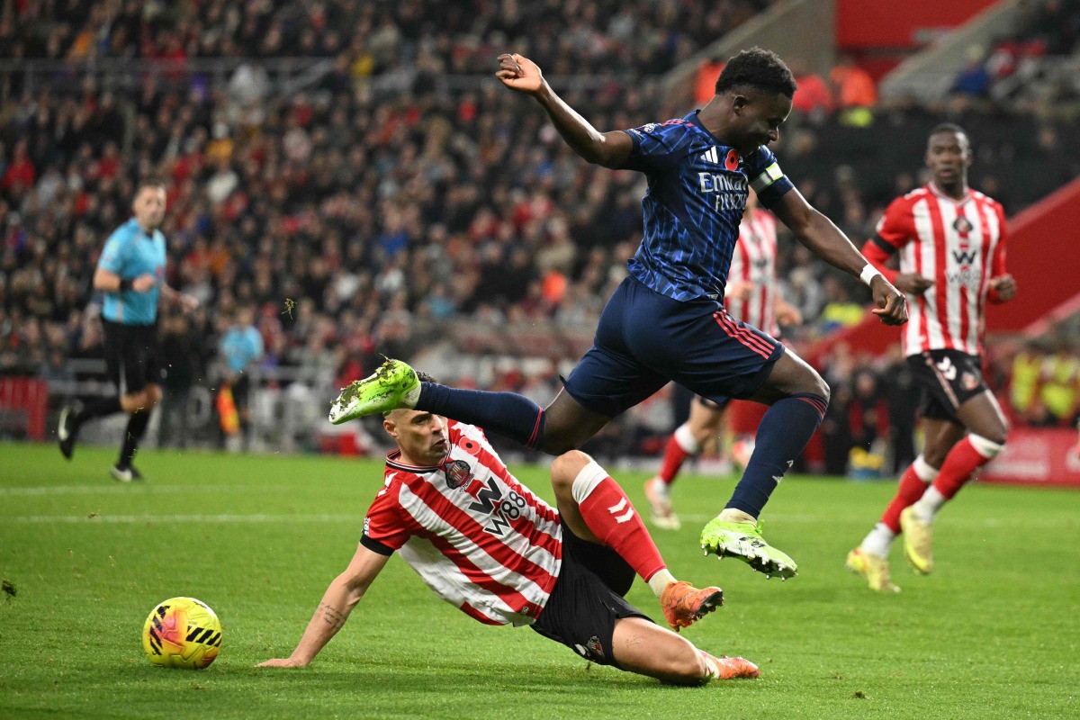Sunderland's Swiss midfielder #34 Granit Xhaka (L) tackles Arsenal's English midfielder #07 Bukayo Saka (R) during the English Premier League football match between Sunderland and Arsenal at The Stadium of Light in Sunderland in north east England on November 8, 2025. (Photo by Oli SCARFF / AFP)