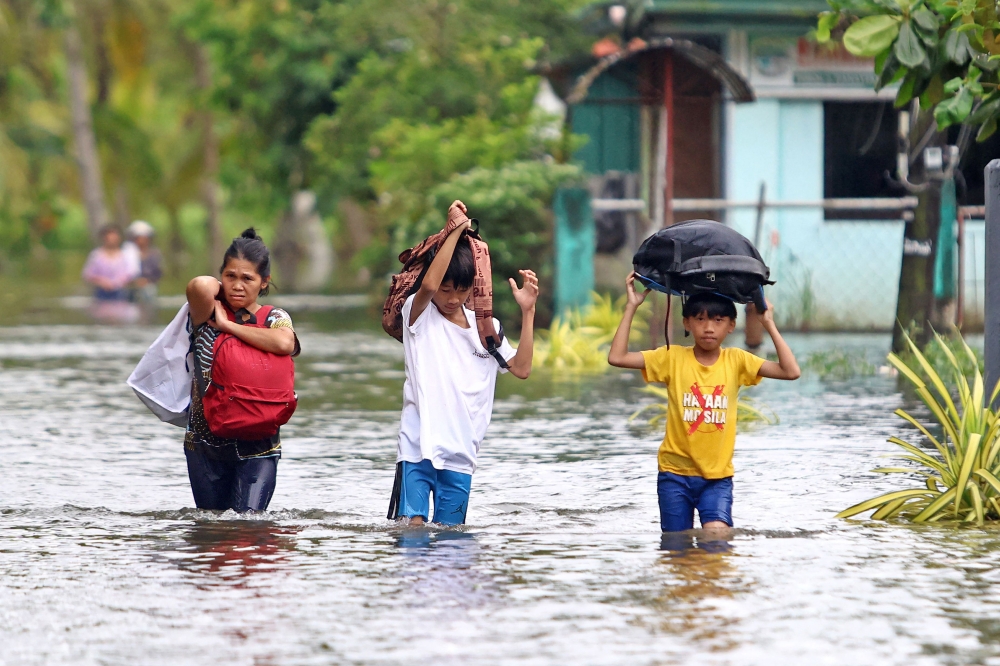 Residents evacuate from their flooded homes due to heavy rain brought by Typhoon Fung-wong in Remedios T. Romualdez. Photo by Erwin Mascarinas/ AFP