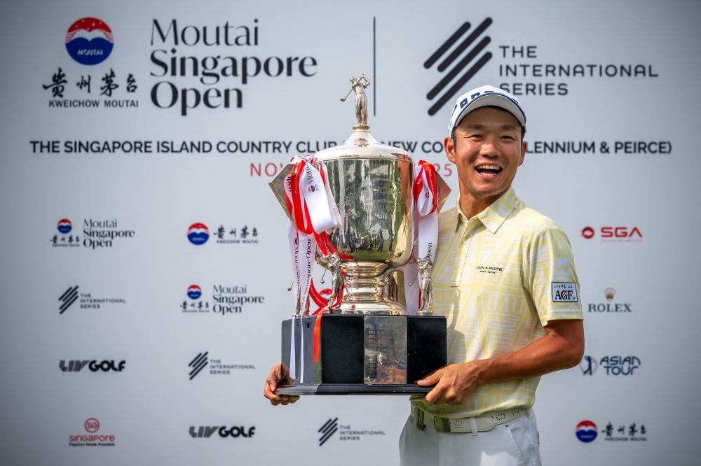 This handout photograph from the Asian Tour taken and received on November 9, 2025 shows Japan's Yosuke Asaji posing with the trophy after the 2025 Moutai Singapore Open golf tournament. (Photo by Graham Uden / Asian Tour / AFP) 