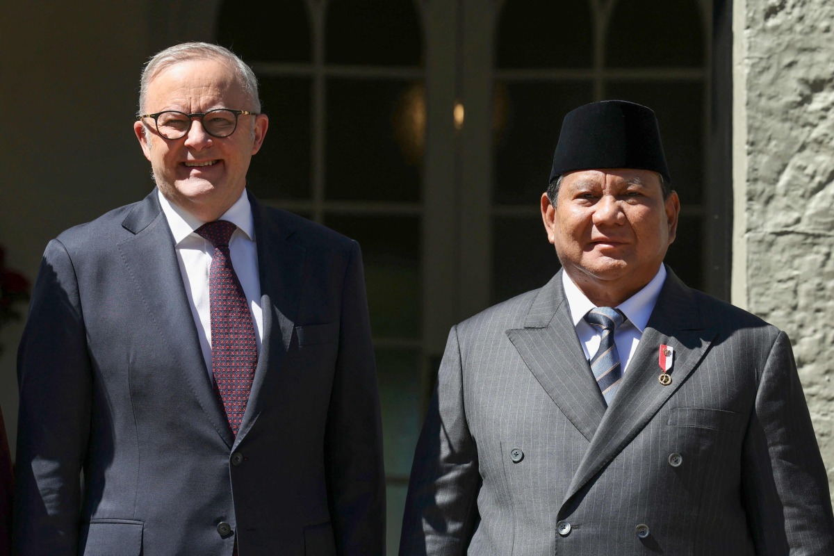 Australia's Prime Minister Anthony Albanese (L) greets Indonesia's President Prabowo Subianto at Kirribilli House in Sydney on November 12, 2025. (Photo by Hollie Adams / POOL / AFP)