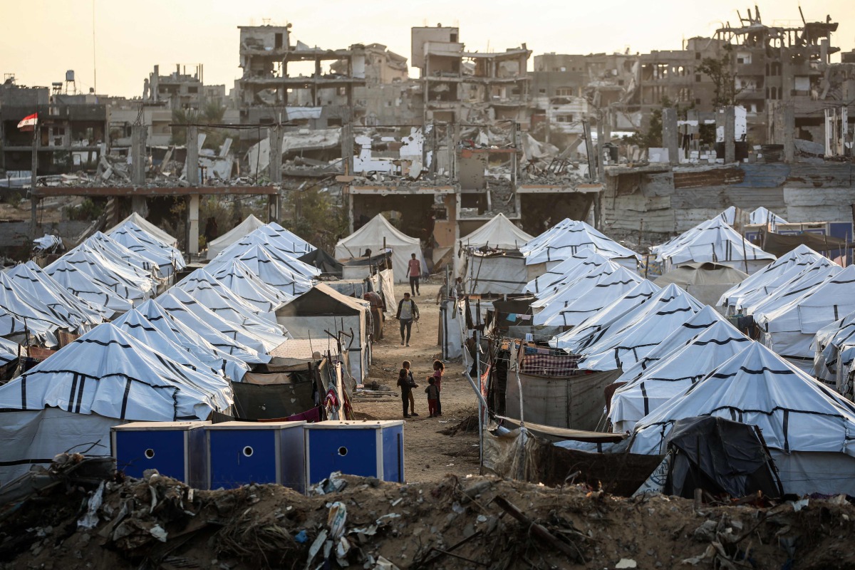 Young Palestinian girls play in a new displacement camp set up by the Egyptian Committee in Nuseirat, Gaza Strip on November 11, 2025. (Photo by Eyad Baba / AFP)