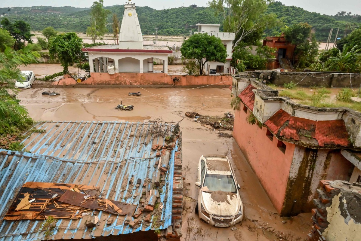 File photo: A damaged car is pictured under mud and debris after heavy rains induced flood in Jammu on August 27, 2025. Photo by AFP