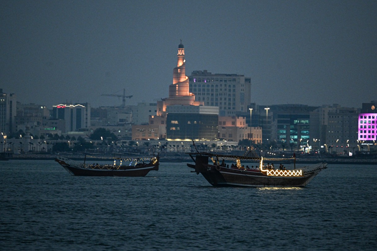 Tourists ride traditional boats along the corniche promenade in Doha on November 12, 2025. Photo by Mahmud HAMS / AFP