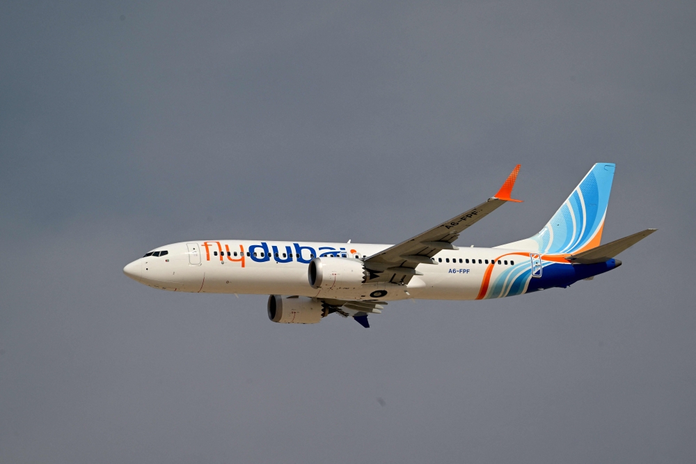 A Flydubai Boeing 737 MAX 8 performs a display flight at Al-Maktoum International Airport during the Dubai Airshow 2025 in Dubai on November 17, 2025. (Photo by Giuseppe CACACE / AFP)