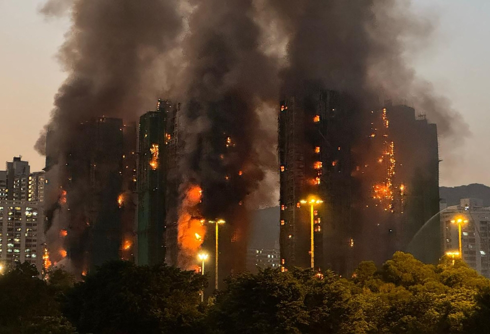 Thick smoke and flames rise as a major fire engulfs several apartment blocks at the Wang Fuk Court residential estate in Hong Kong's Tai Po district on November 26, 2025. (Photo by Yan ZHAO / AFP)