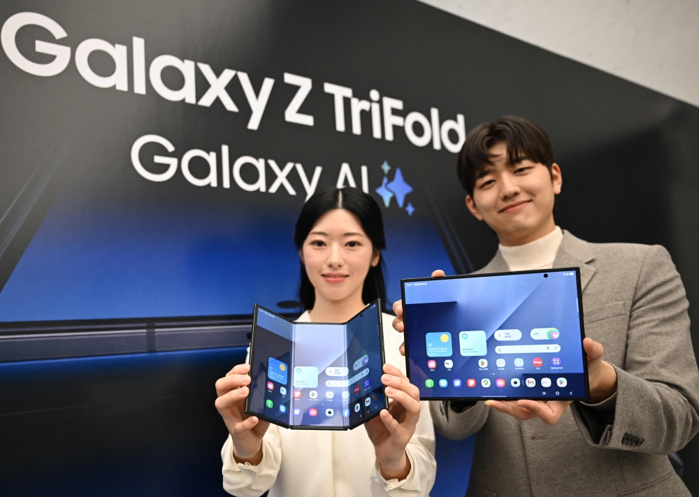 Promoters show Samsung Galaxy Z TriFold smartphones during a launch event at a Samsung store in Seoul on December 2, 2025. (Photo by Jung Yeon-je / AFP)