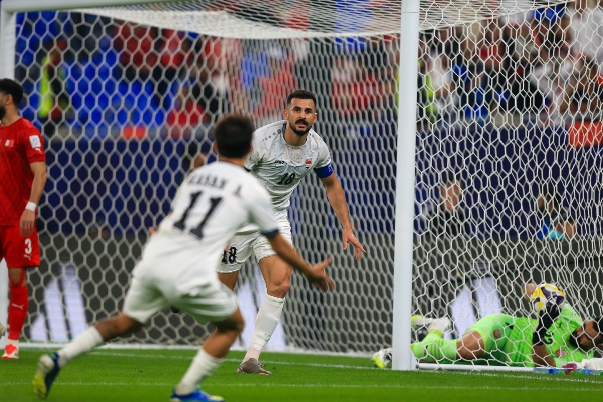 Iraq players celebrate an own goal by Bahrain goalkeeper Ebrahim Lutfalla.