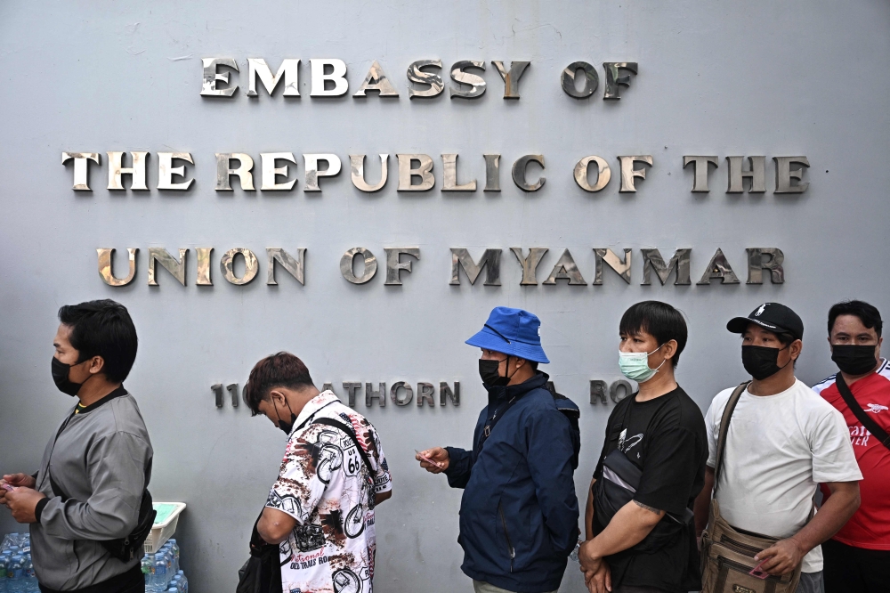Myanmar nationals living in Thailand queue up outside the Myanmar Embassy for early voting ahead of the Myanmar general election, in Bangkok on December 6, 2025. (Photo by Lillian Suwanrumpha / AFP)
 