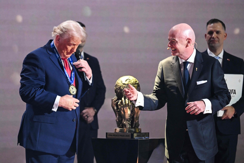 US President Donald Trump reacts as he receives the FIFA Peace Prize from Italian Fifa President Gianni Infantino at the Kennedy Center, in Washington, DC, on December 5, 2025. (Photo by Saul Loeb / AFP)
 
