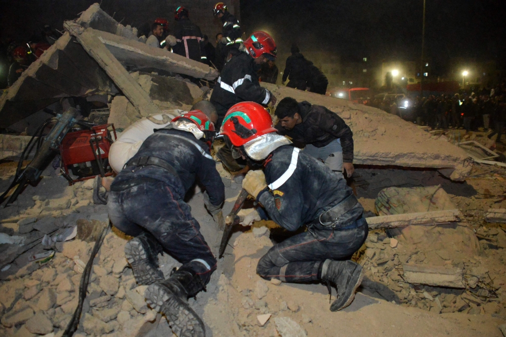 Emergency personnel search for victims in the rubble of two collapsed buildings in the Al Massira area of Fes late on December 9, 2025. (Photo by Ahmed Alaoui Mrani / AFP)
