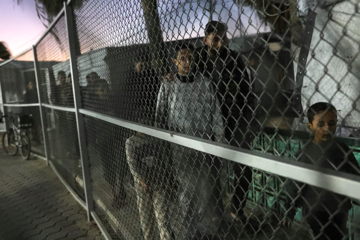 Family members walk with a Palestinian youth who was released from Israeli prisons under as a Gaza ceasefire and hostage exchange deal after his arrival in Khan Yunis, in the southern Gaza Strip on December 2, 2025. Photo by BASHAR TALEB / AFP
