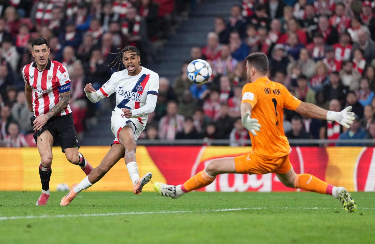 Paris Saint-Germain's French forward #29 Bradley Barcola challenges Athletic Bilbao's Spanish goalkeeper #01 Unai Simon during the UEFA Champions League league phase day 6 football match between Athletic Club Bilbao and Paris Saint-Germain (PSG) at San Mames Stadium in Bilbao on December 10, 2025. (Photo by Cesar MANSO / AFP)
