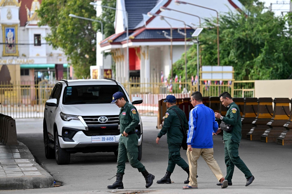 Cambodian police officials walk at the closed Poipet International border checkpoint between Cambodia and Thailand in Poipet, Banteay Meanchey province on December 12, 2025, amid clashes along the Cambodia-Thailand border. (Photo by Tang Chhin Sothy / AFP)