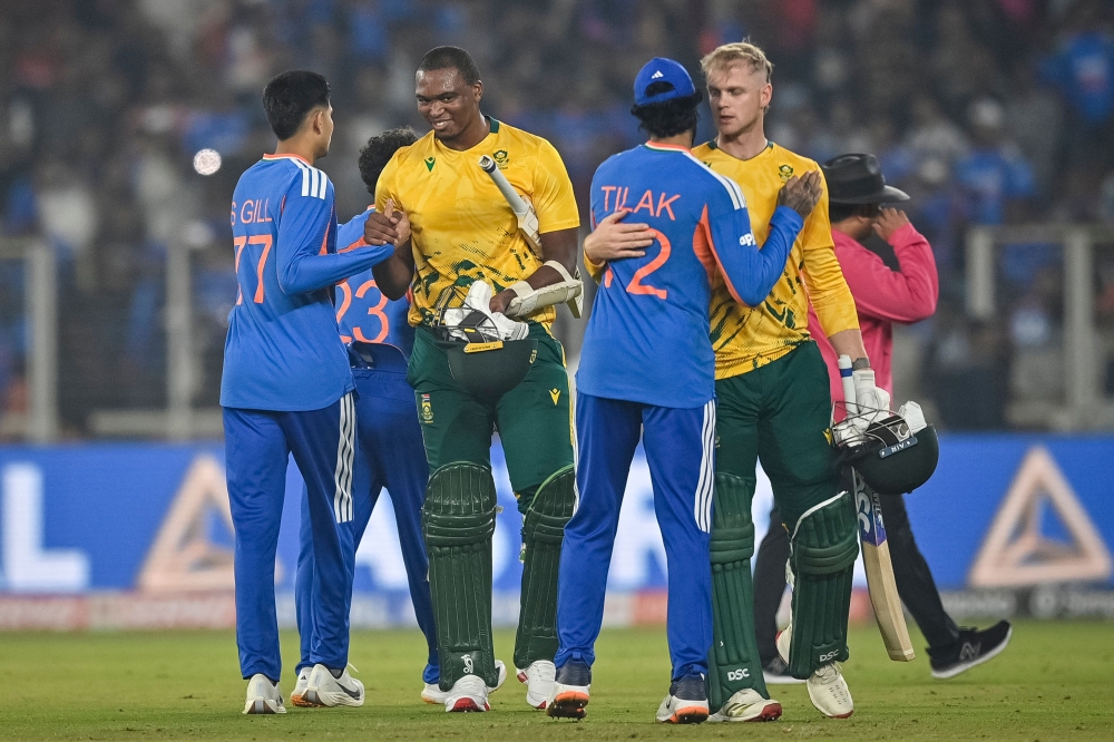 South Africa's Lungi Ngidi (2L) and Corbin Bosch (2R) congratulate India's Shubman Gill and Tilak Varma for their team's win at the end of the fifth Twenty20 international cricket match between India and South Africa at the Narendra Modi Stadium in Ahmedabad on December 19, 2025. (Photo by Shammi Mehra / AFP) 