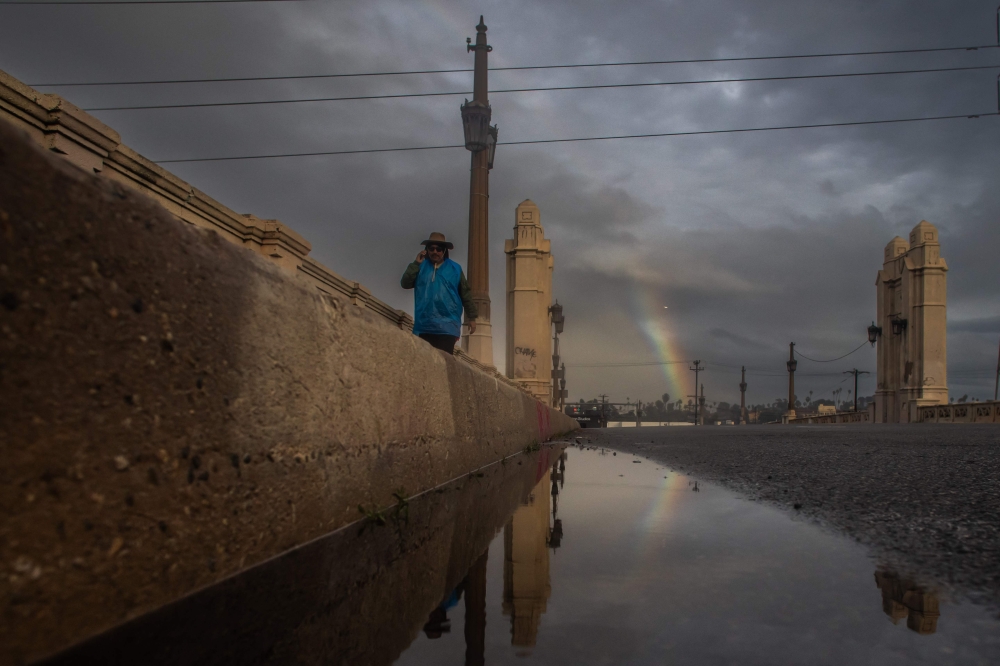 A rainbow is seen over the 4th Street Bridge after heavy rains in downtown Los Angeles on December 24, 2025. (Photo by Apu Gomes / AFP)