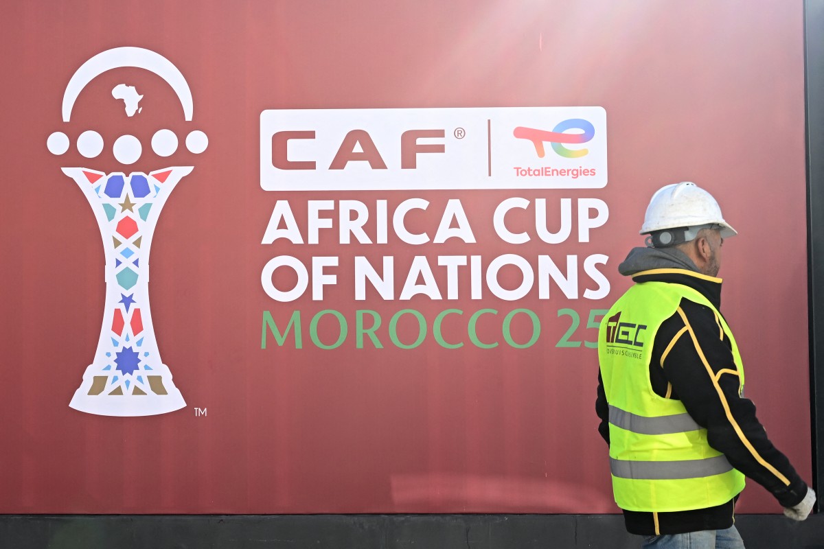 An employee walks past the games' logo outside of the Al-Medina Stadium in Rabat, on December 18, 2025, ahead of the Africa Cup of Nations (AFCON).
