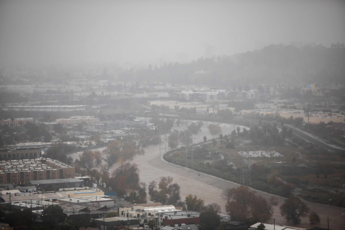 The Los Angeles river with a high water level is seen from Elysian Park on December 24, 2025 in Los Angeles, California. (Photo by Apu GOMES / AFP)
