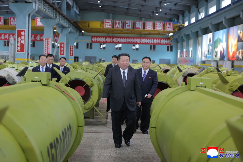 This undated picture released by North Korea's official Korean Central News Agency (KCNA) on December 26, 2025 shows North Korean leader Kim Jong Un (C) visiting major munitions industry enterprises to acquaint himself with the missile and shell production at an undisclosed place in North Korea. (Photo by KCNA VIA KNS / AFP) 