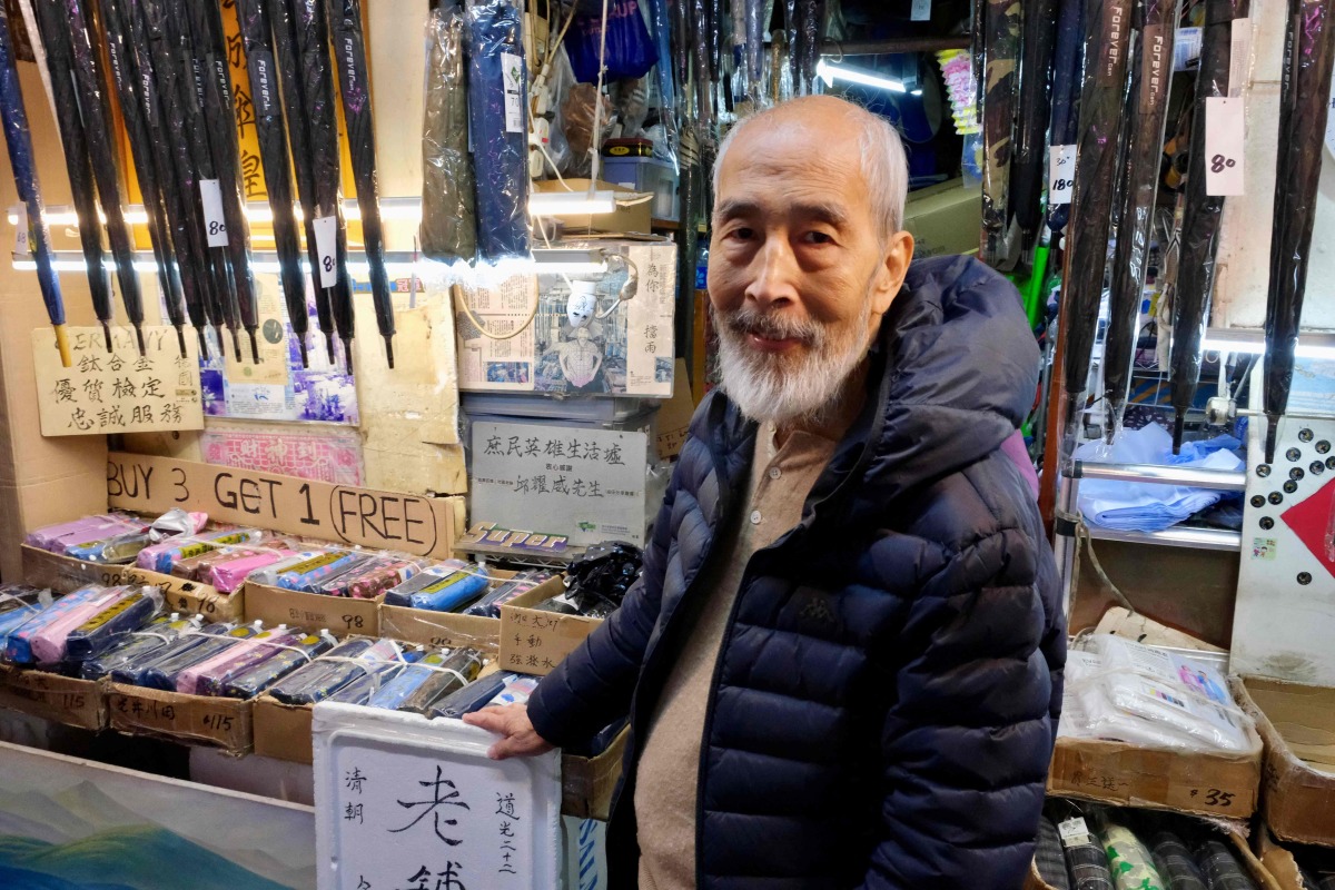 Yau Yiu-wai, 73, one of the few remaining umbrella repairmen in Hong Kong, poses poses for a photo in Hong Kong's Sham Shui Po district on December 26, 2025. Photo by Tommy WANG / AFP