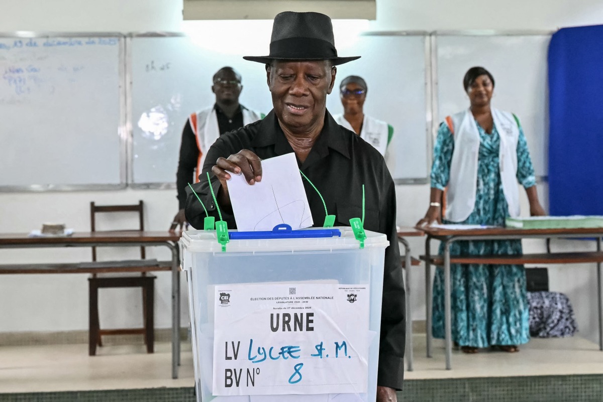 Ivory Coast's President Alassane Ouattara casts his ballot at a polling station at the Lycee Saint-Marie in Cocody, Abidjan, on December 27, 2025 during Ivory Coast's legislative elections. (Photo by SIA KAMBOU / AFP)