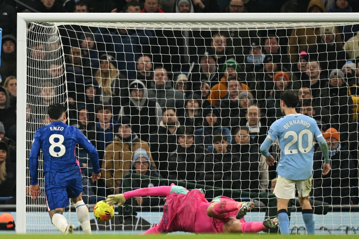 Manchester City's Italian goalkeeper #25 Gianluigi Donnarumma makes a save as Chelsea's Argentinian midfielder #08 Enzo Fernandez prepares to score during the English Premier League football match between Manchester City and Chelsea at the Etihad Stadium in Manchester, north west England, on January 4, 2026. (Photo by Oli SCARFF / AFP)