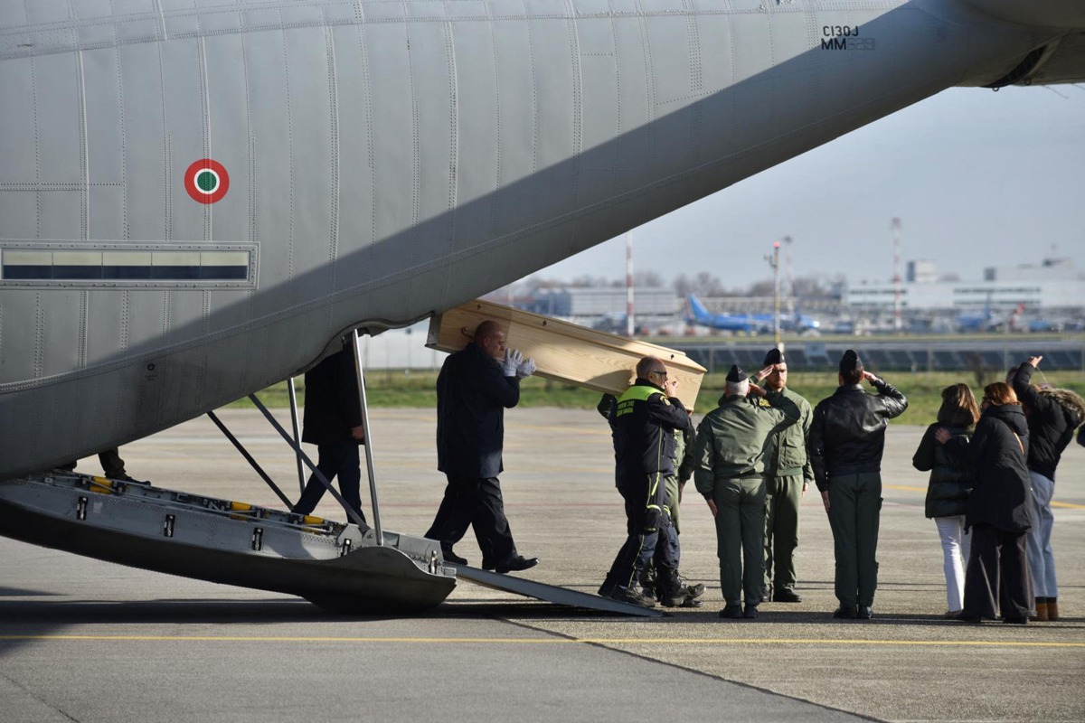 The coffins of four Italian nationals killed in the New Year's fire disaster at Le Constellation in the Alpine ski resort town of Crans-Montana in Switzerland, are carried on the tarmac after the landing of Italian Air Force C130 at Linate Milan airport on January 5, 2026. Photo by MATTEO CORNER / ANSA / AFP