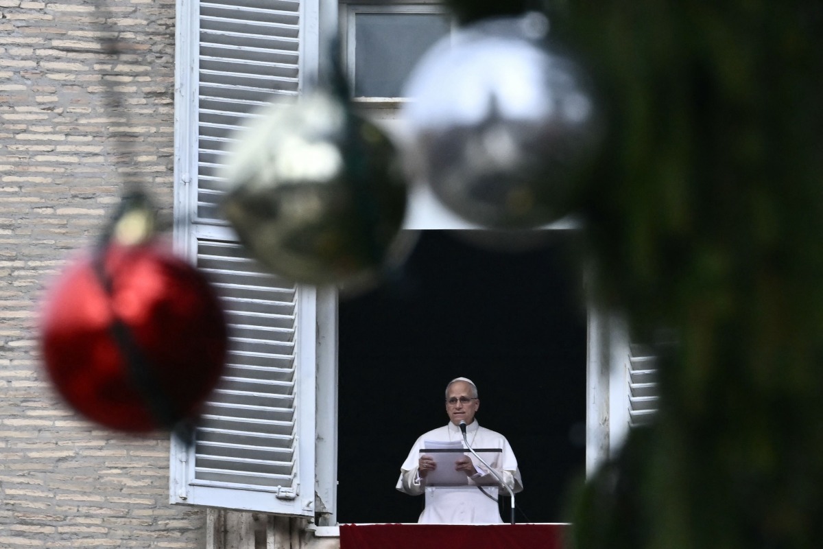 Pope Leo XIV delivers a speech to pilgrims from the window of the apostolic palace overlooking St. Peter's square during his Sunday Angelus prayer at the Vatican on January 4, 2026. (Photo by Filippo MONTEFORTE / AFP)