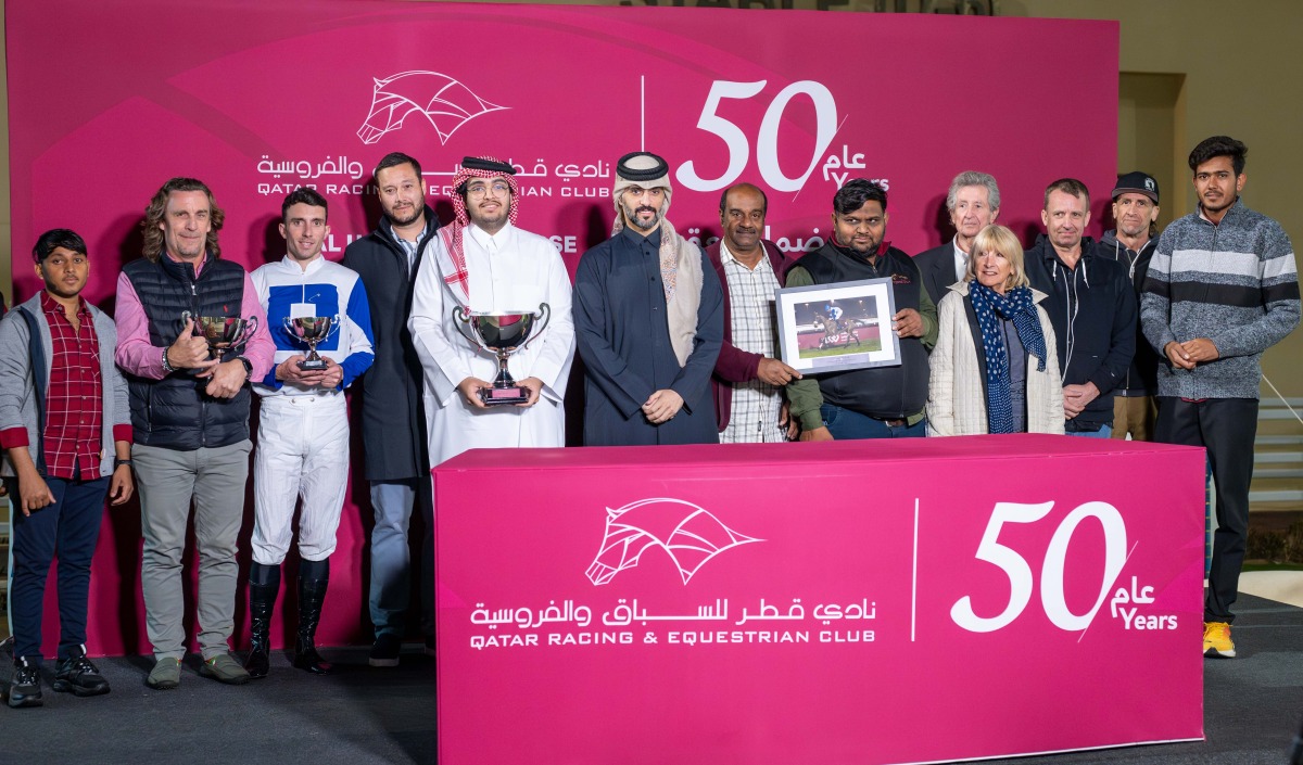 The connections of Lady De Faust pose with their trophies. 