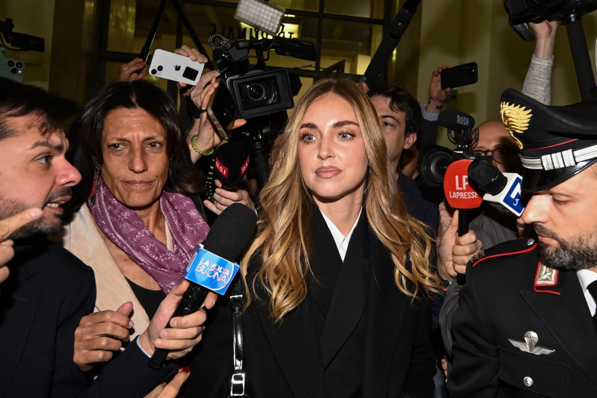 Italian influencer and businesswoman Chiara Ferragni (C), charged for aggravated fraud in a case linked to a Pandoro charity initiative, arrives in the Milan Courthouse in Milan, on January 14, 2026. (Photo by Piero CRUCIATTI / AFP)