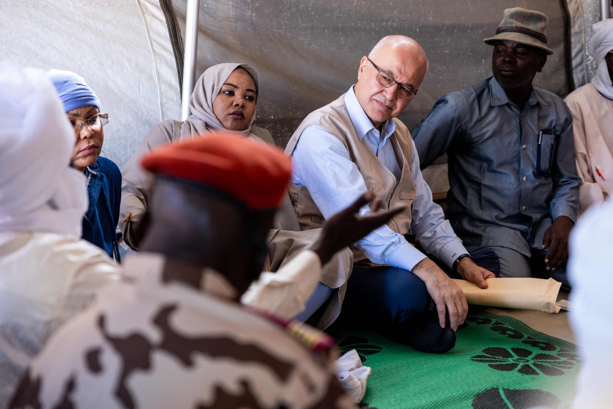 United Nations (UN) High Commissioner for Refugees, Barham Salih (2nd R), talks with a Sudanese refugee, in Farchana, Ouaddai, on January 14, 2026. (Photo by Joris Bolomey / AFP)