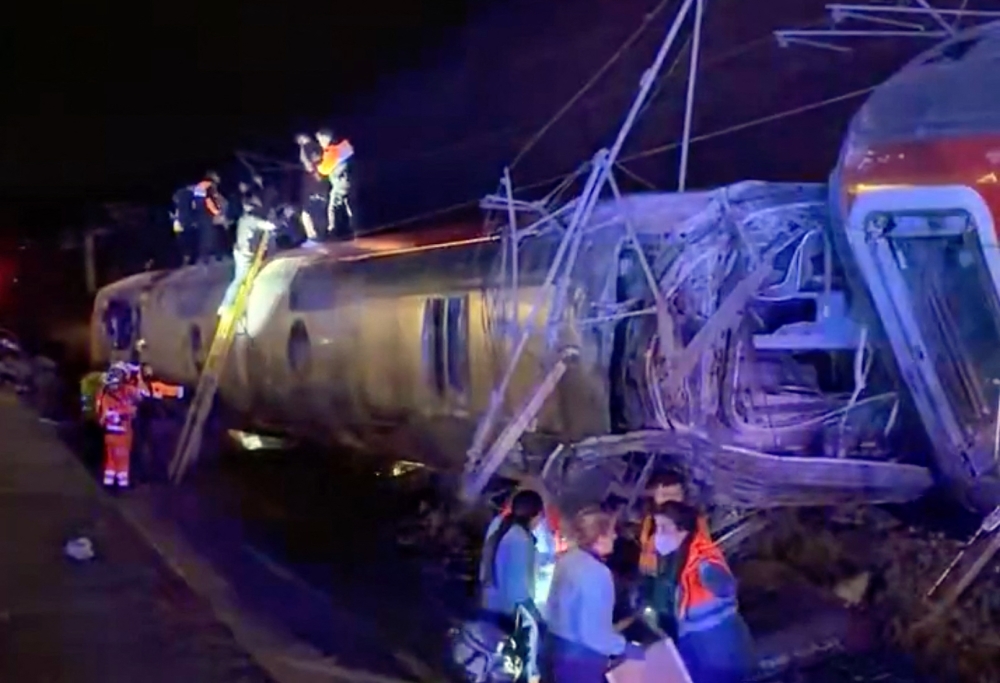 This video grab taken from videos posted on social media and verified by AFPTV teams in Madrid, shows emergency personnel working after a train accident in Adamuz, southern Spain, on January 18, 2026. (Photo by -UGC / @eleanorinthesky (via X) / AFP) 