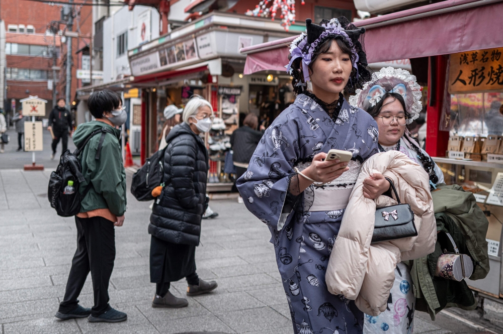 People visit a shopping street in Asakusa district near Sensoji Temple, a popular tourist location in Tokyo on January 20, 2026. (Photo by Philip Fong / AFP)
 