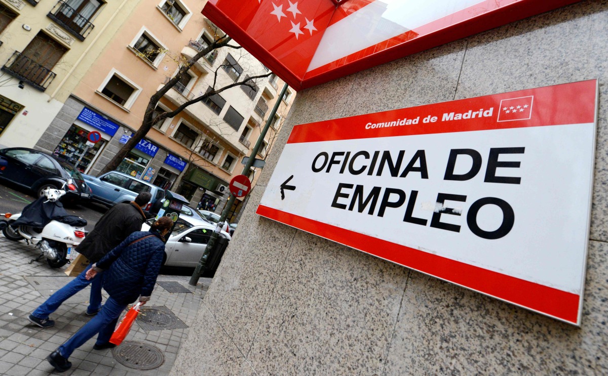 People walk outside a government employment office in the center of Madrid on January 3, 2014. Photo by GERARD JULIEN / AFP