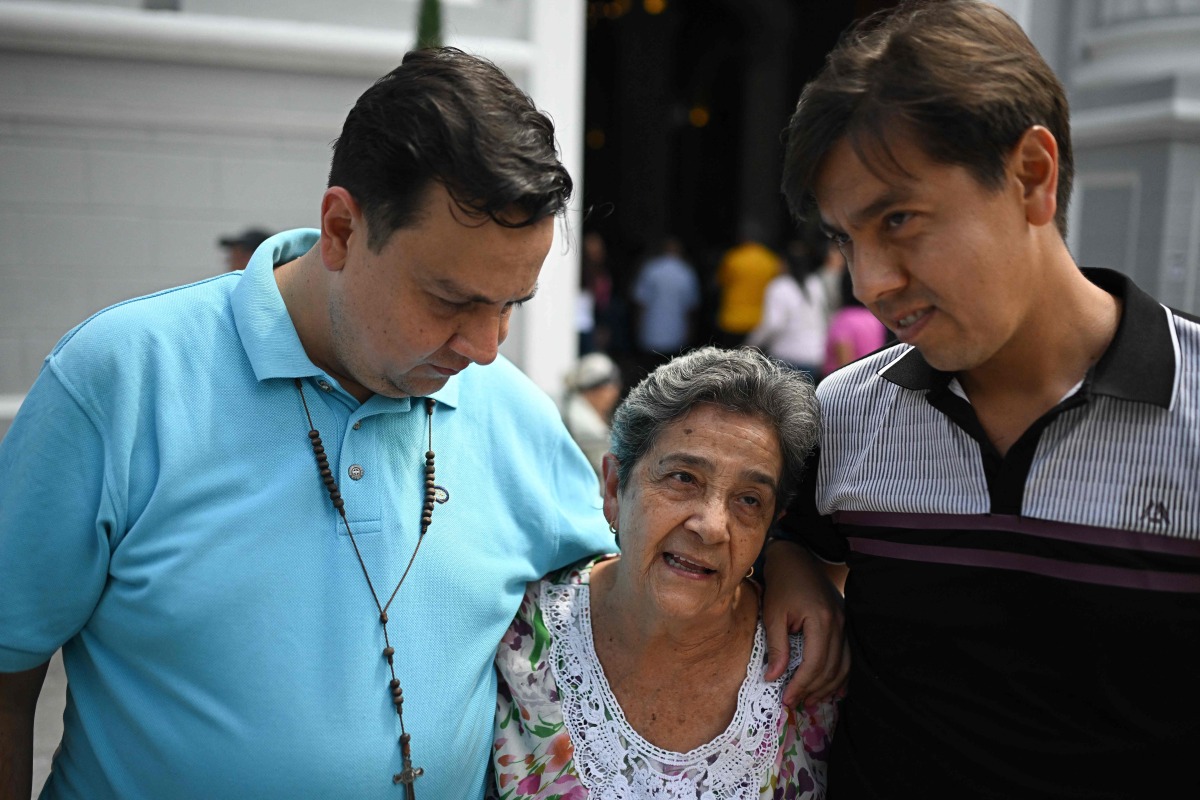 Human rights activist Javier Tarazona (L) greets his brother Jose Rafael Tarazona (R) and his mother Teresa de Jesus Sanchez after his release from prison at La Candelaria church in Caracas on February 1, 2026. (Photo by Federico PARRA / AFP)