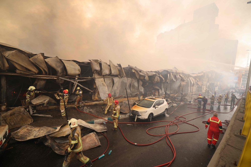 Smoke rises as firefighters battle a fire that broke out in Jannat Bazaar, west of Tehran on February 3, 2026. Photo by Atta Kenare / AFP 