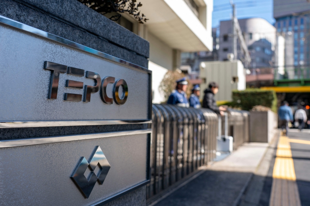 The logo of Tokyo Electric Power Company is seen at an entrance to the company's headquarters in Tokyo on February 9, 2026. (Photo by Kazuhiro NOGI / AFP)