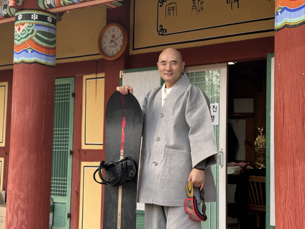 This picture taken on on February 12, 2026 shows Venerable Hosan, head monk of Bongsunsa Temple, posing for a photo with his snowboard during an interview at the temple in Namyangju. (Photo by YONHAP / AFP) 