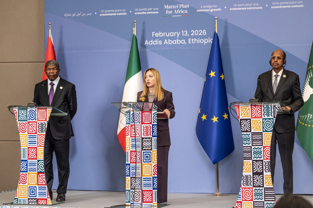 Italian Prime Minister Giorgia Meloni (C) speaks as Angola President Joao Lourenco (L), and Mahmoud Ali Youssouf (R), Chairperson of the African Union Commission, listen on during the closing press conference of the Second Italy-Africa Summit at the Addis International Convention Center (AICC) in Addis Ababa on February 13, 2026. (Photo by Marco Simoncelli / AFP)
