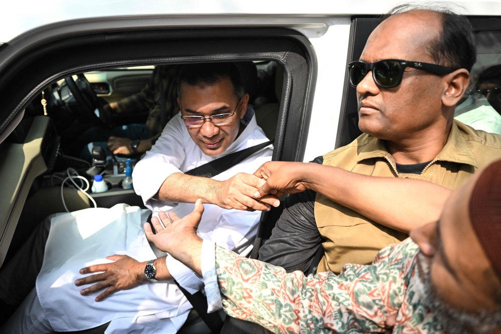 Bangladesh Nationalist Party (BNP) chairman and election candidate Tarique Rahman (L) greets his supporters in Dhaka on February 13, 2026. (Photo by Munir Uz Zaman / AFP)
