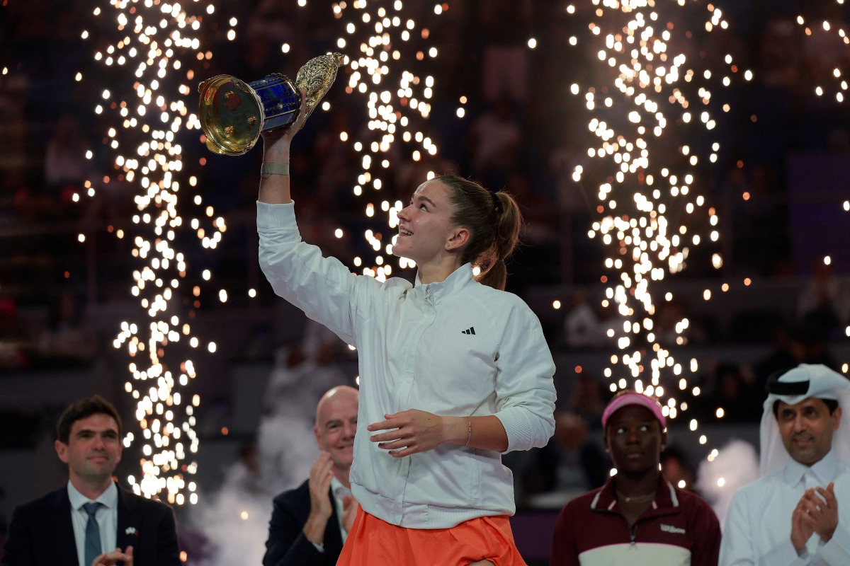 Czech Republic's Karolina Muchova reacts as she holds up the winner's trophy after beating Canada's Victoria Mboko in the women singles final match, at the Qatar Open tennis tournament in Doha on February 14, 2026. (Photo by Karim JAAFAR / AFP)