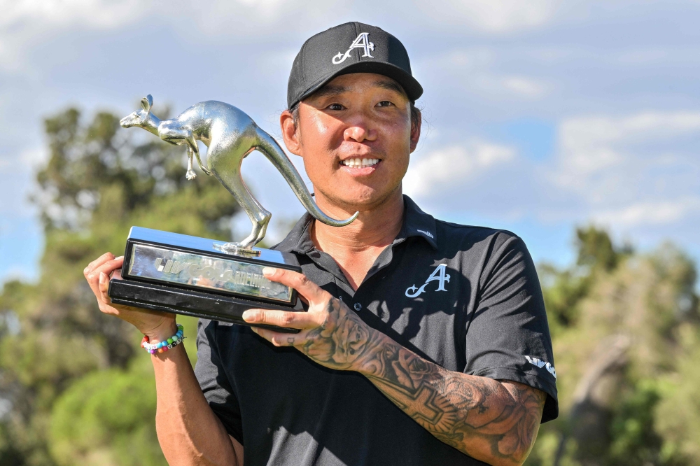 4Aces GC player Anthony Kim from the US celebrates with the trophy after winning the LIV Golf Adelaide tournament at The Grange Golf Club in Adelaide on February 15, 2026. (Photo by Brenton Edwards / AFP)