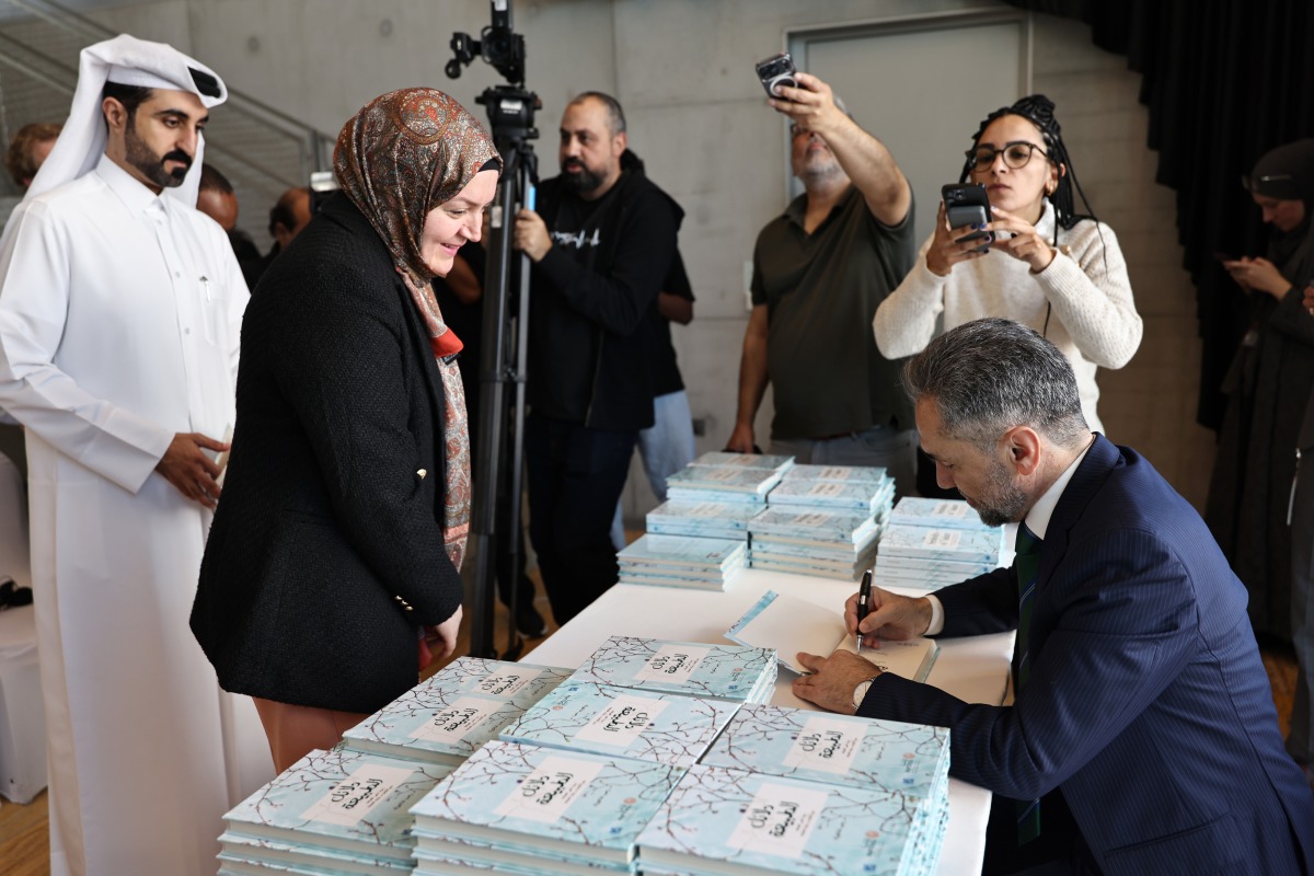 Dr. Recep Şentürk signs copies of his book at the launch ceremony yesterday. Pic: Salim Matramkot/THE PENINSULA  