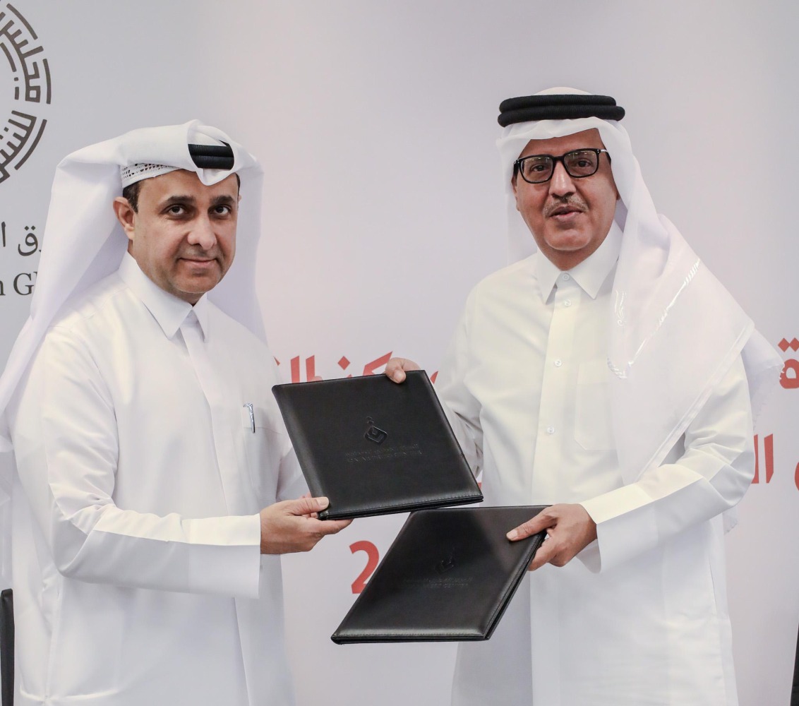 Director General of Qatar Press Center Sadiq Al-Amari and Executive Director of the Middle East Council on Global Affairs Khalid Al-Jaber exchanging documents after signing the agreement.