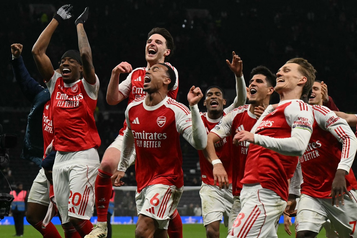 Arsenal celebrate their victory at the end of the English Premier League football match between Tottenham Hotspur and Arsenal at the Tottenham Hotspur Stadium in London, on February 22, 2026. (Photo by Glyn KIRK / AFP)