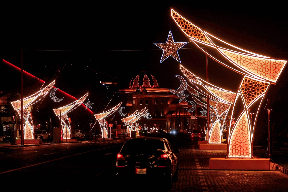 Vehicles move along the road beneath light decorations for Ramadan in Katara Cultural Village in Doha early on February 23, 2026. (Photo by Karim Jaafar / AFP)